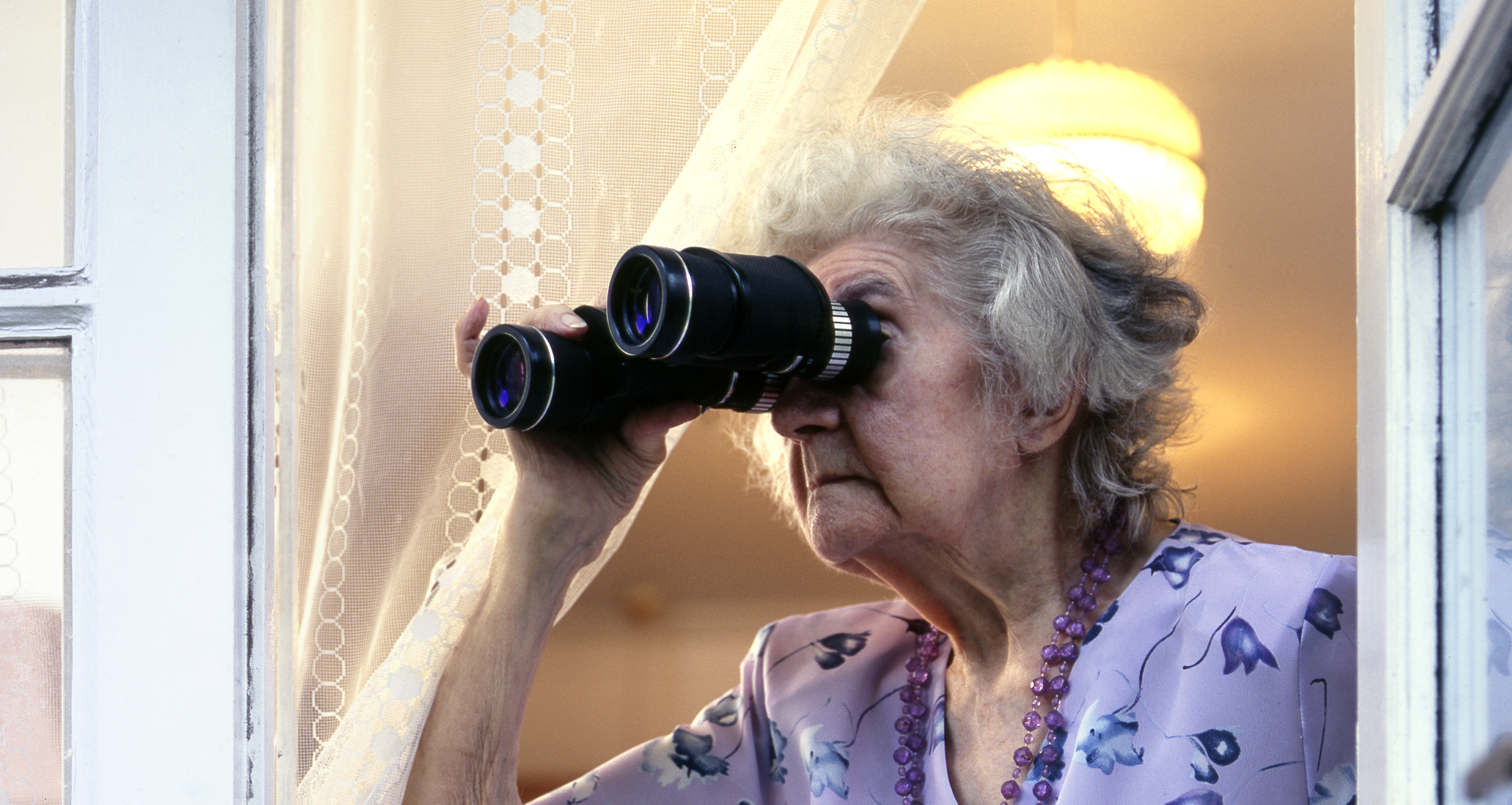 A senior woman looking through binoculars | Source: Getty Images