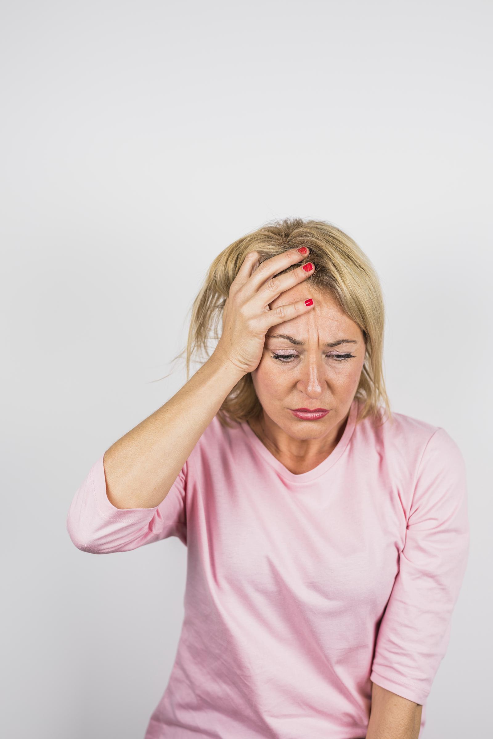 A sad woman with her hand on her forehead | Source: Freepik